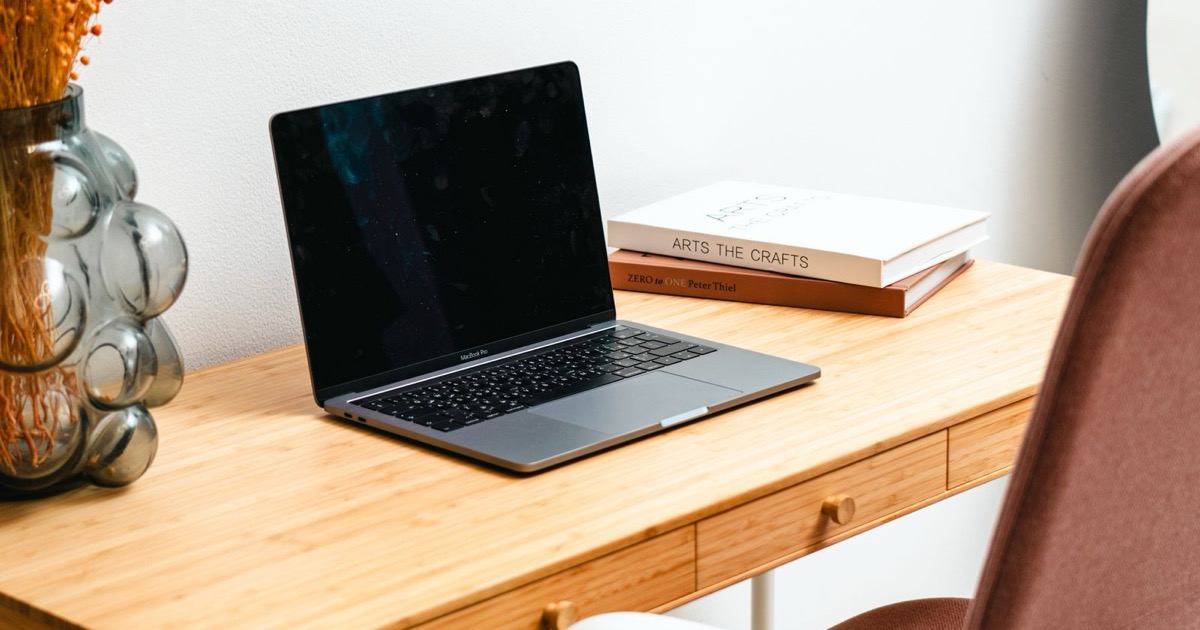 Open laptop on a minimal, warm-toned home office desk, evoking the workspace where a Canadian therapist reviews Google Workspace privacy settings