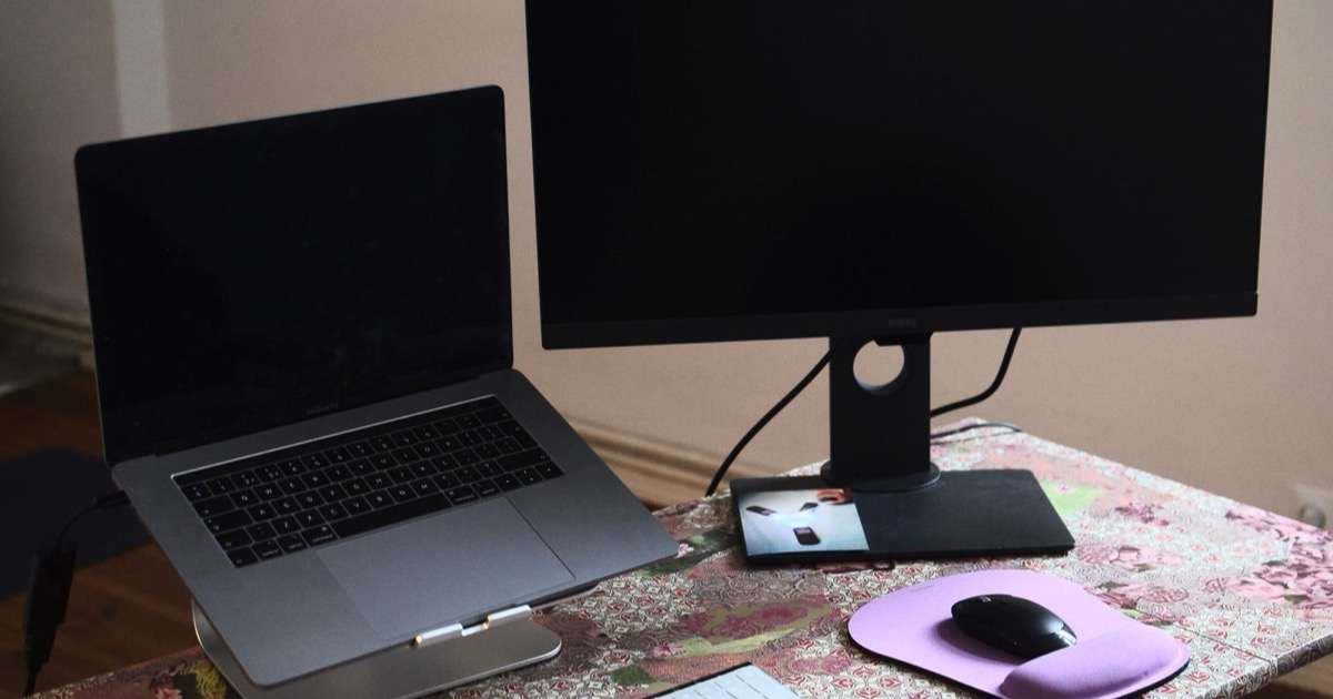 A laptop and external monitor on a tidy office desk, representing a Canadian therapist setting up Google Workspace for PHIPA