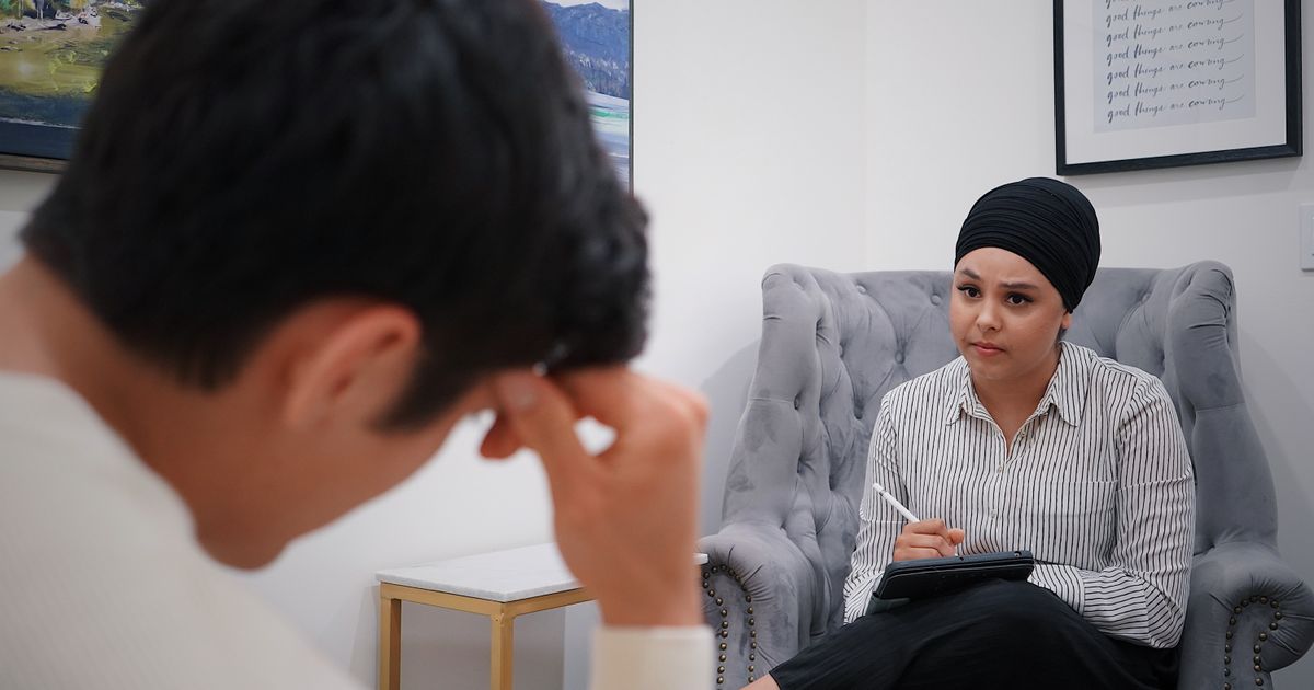 A therapist takes notes on a tablet during a counselling session with a client, representing an Ontario therapist weighing how AI and digital tools handle client health data under PHIPA
