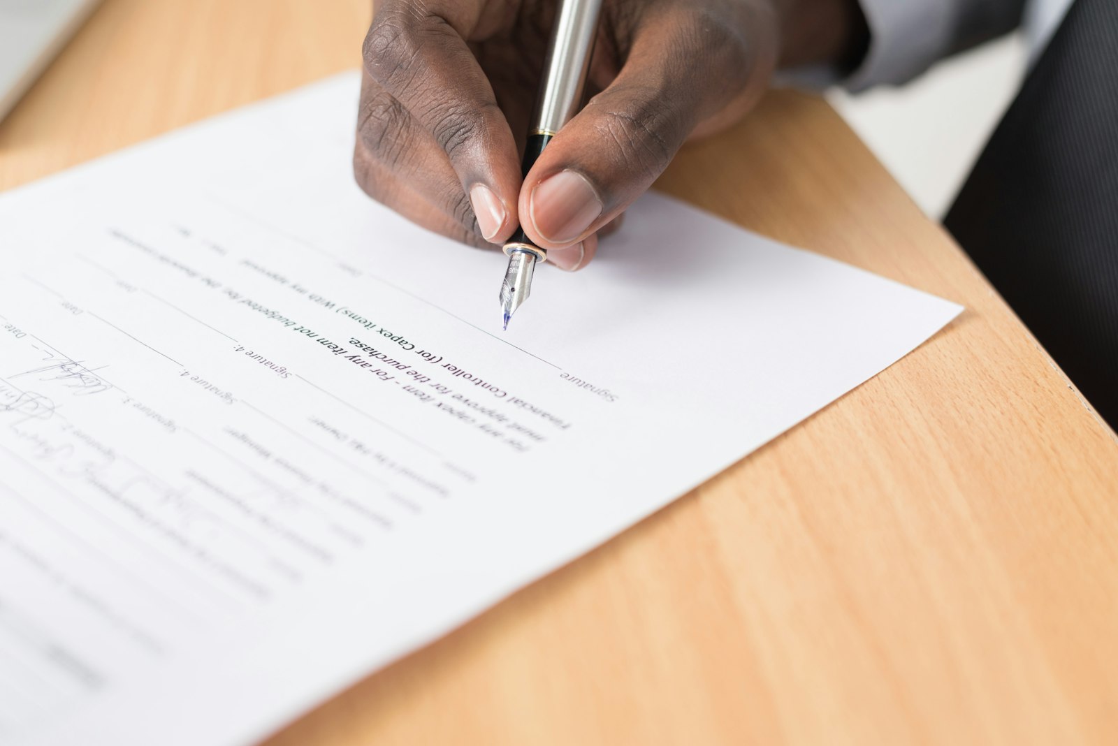 Hand signing a consent form, illustrating PHIPA s.18 knowledgeable consent and CRPO Standard 3.4 informed consent for therapist email
