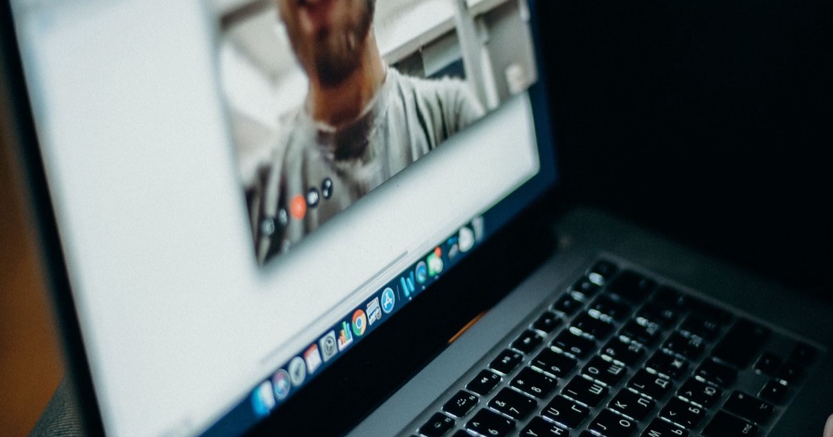 A laptop on a desk during a video call, representing a therapist's telehealth session